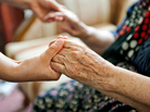 A young woman holding an elderly woman's hands A young woman holding an elderly woman's hands